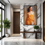 Hungarian Grace – Art Fusion framed canvas portrait of a young Hungarian woman, 1940 – Art Fusion Store Modern interior with a marble wall, wooden bench, and framed portrait of a woman in an orange dress.