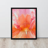 Framed pink and orange tulip print on a light wooden floor and white wall.