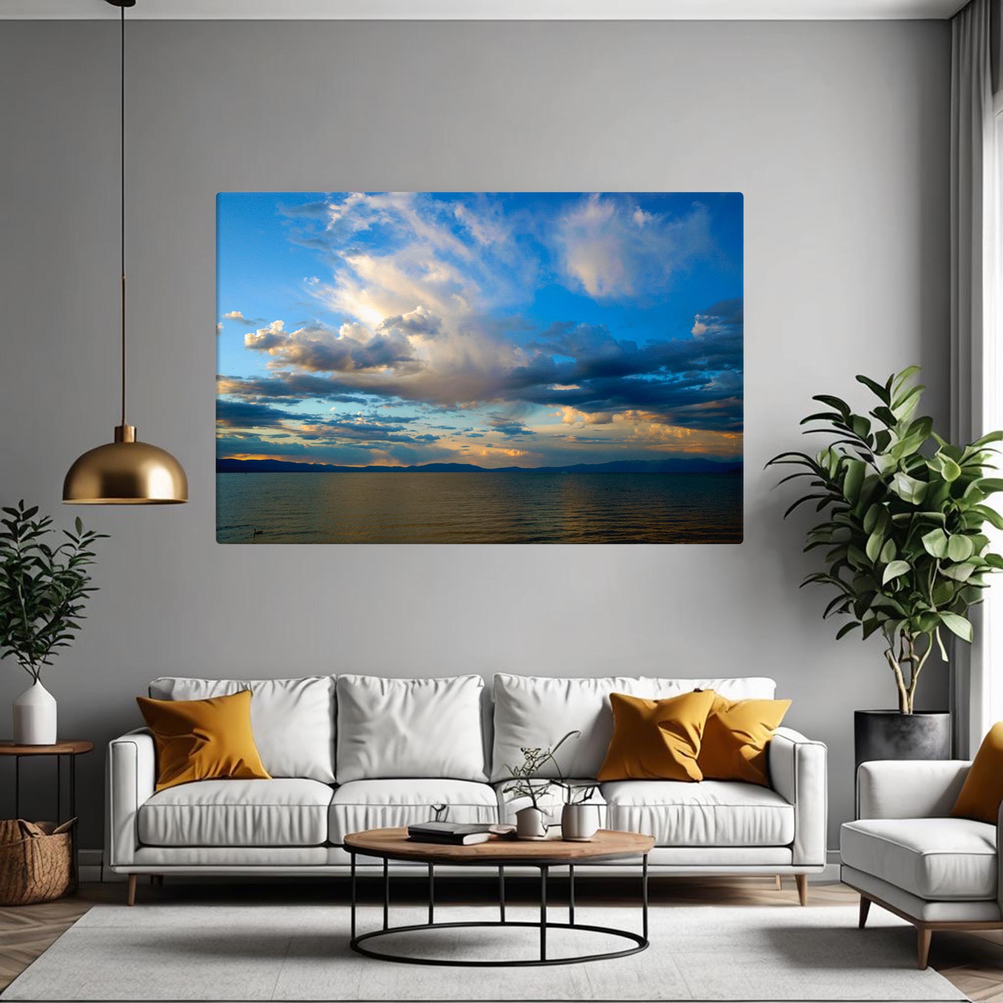 Living room with a large wall-mounted canvas of a sunset over water, a white sofa with yellow cushions, and a gold pendant light.