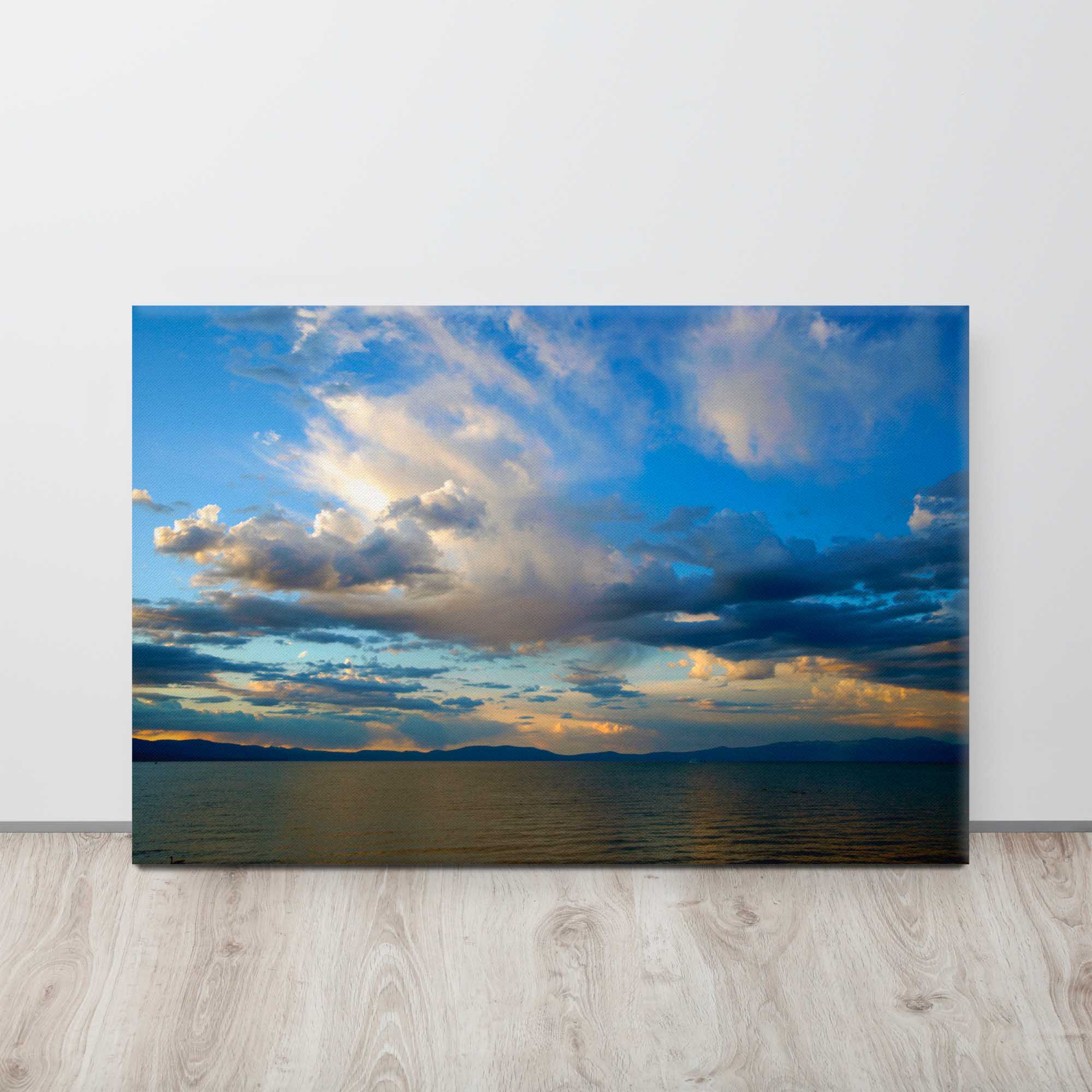 Canvas print of a sunset over a body of water with clouds.