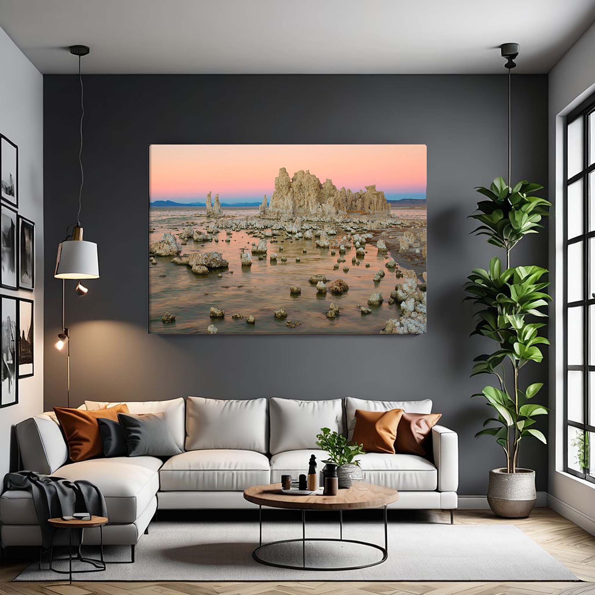 Living room with a large wall-mounted canvas displaying a natural landscape, a white sofa with pillows, a coffee table, and a plant.