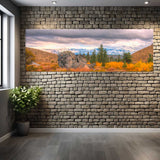 Large wall mural of a scenic landscape on a stone wall in a room.